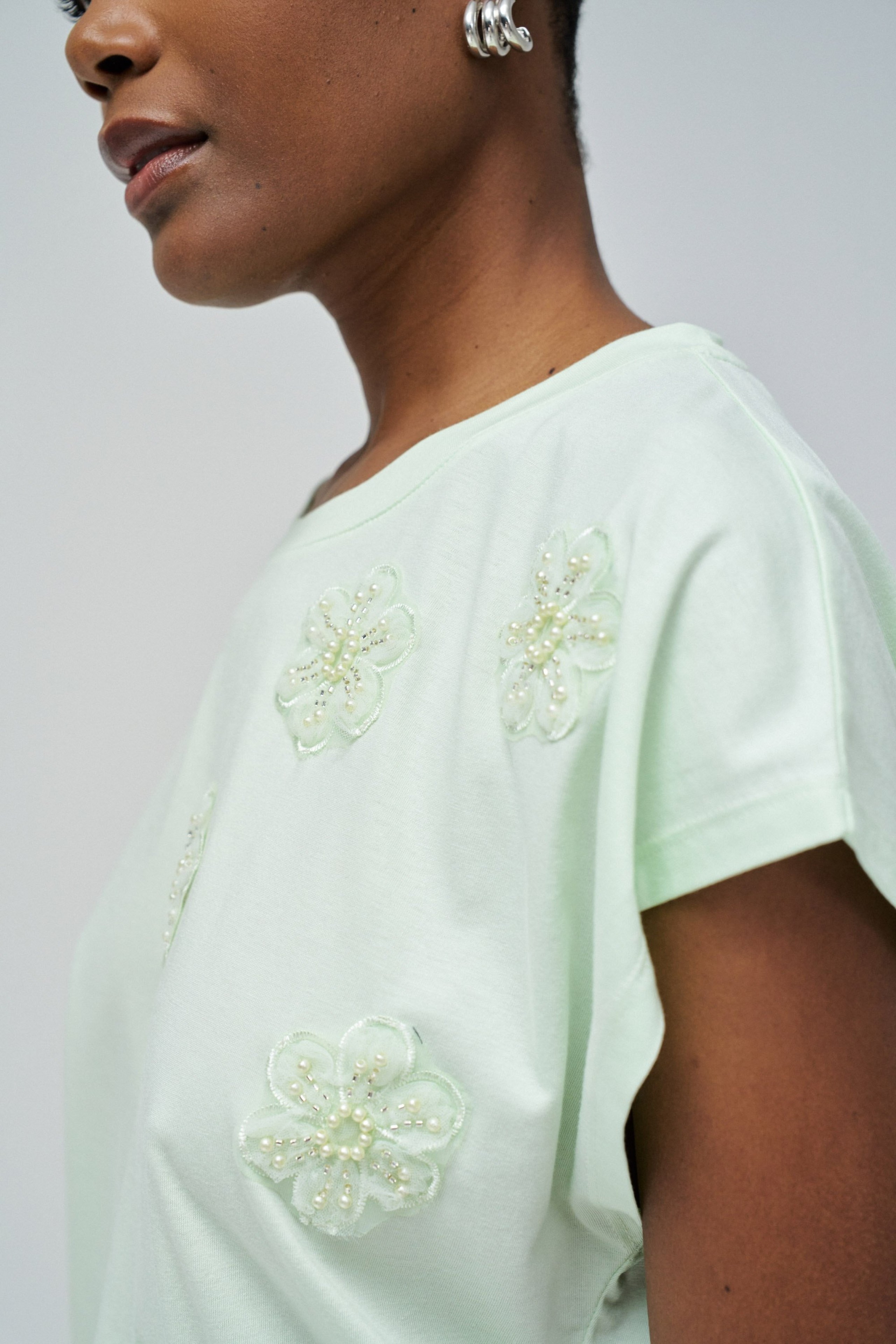 T-SHIRT MIT BLUMENAPPLIKATIONEN